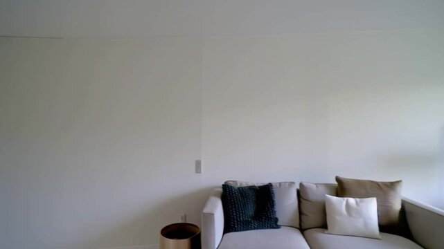 empty white room, and use a time-lapse to assemble the living room step by step: the sofa is placed first, followed by the coffee table .