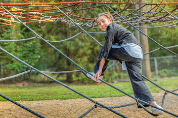 Spider's Web ride is climbed by a teenage girl. Copy space