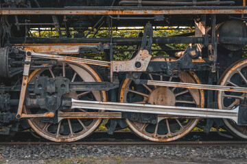 metal wheels and the driving mechanism of an old vintage steam locomotive powered by coal. rusty metal and steel