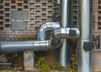 central heating pipes in the city with thermal insulation, large silver pipes for transmitting heat...