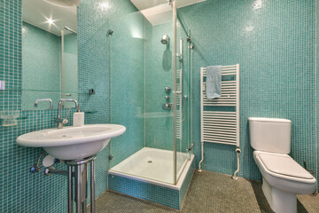 A contemporary bathroom featuring a turquoise tile design, glass shower enclosure, and sleek sanitary ware for a fresh and vibrant look.