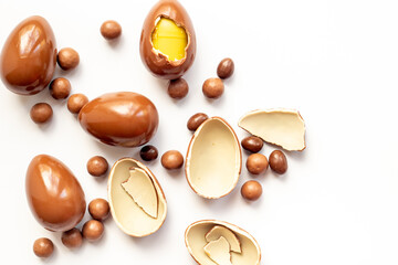 Chocolate background. Broken and whole chocolate eggs, top view