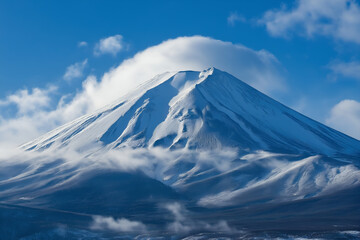 A snow-covered mountain peak with clouds swirling around it.