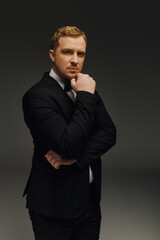 Fototapeta premium Handsome man poses confidently in elegant tuxedo during studio photoshoot session