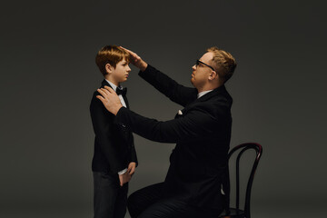 Father and son share a moment of elegance in stylish bow ties at the studio
