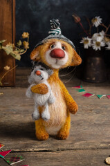 Do-it-yourself knitted toy - a red cat in a hat with a mouse in his hands on a wooden background. Crochet soft toys. Love and Valentine's Day concept.