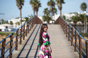 Latin woman, brunette, with flowing hair, dancing flamenco on a wooden catwalk by the seashore. The...