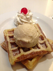 Belgium waffles with chocolate sauce, ice cream and cherry in white plate 