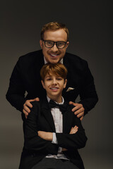 Elegant father and son showcase timeless style in a modern studio setting