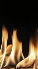 Flames flicker and dance in a darkened setting, creating a warm glow that illuminates the surrounding area