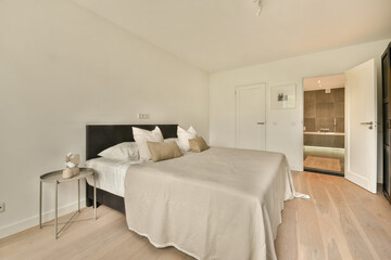A stylish modern bedroom featuring a neutral color palette, minimal furnishings, and elegant decor. Soft lighting enhances the serene atmosphere.