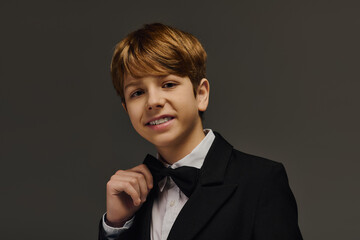 Elegant preteen boy shines in stylish attire during fashion studio session