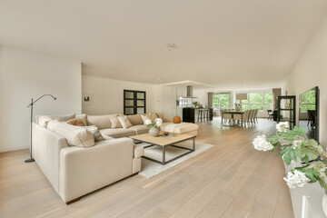 Fototapeta premium Spacious and beautifully designed living room featuring a light color palette, elegant furnishings, and ample natural light creating a serene atmosphere.