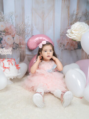 Generated A little girl in pink clothing celebrates in a fairy-tale setting with pastel decorations, a large pink balloon in the shape of a two, and white flowers, radiating joy and innocence.