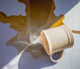 glass of coffee spills on the table.
