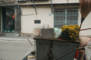 A lively urban street scene featuring a charming cart brimming with vibrant, colorful flowers against a muted backdrop