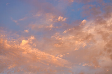 A beautiful sky tinted by the sun leaving vibrant shades of gold, pink, blue and multicolored. Clouds in the twilight evening and morning sky. Cloudy sky background in the evening, and during the day.