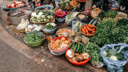 A vibrant and colorful display showcasing a variety of fresh vegetables and herbs found at a bustling market stall