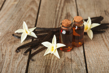 Vanilla extract in glassware on a wooden table. Vanilla extract for baking and desserts. Aromatic Homemade Vanilla Extract. Close -up. Place for the text. Copy space.
