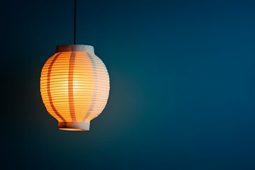 Obraz premium A glowing paper lantern illuminates the blue background with warm light
