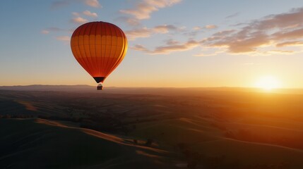 Obraz premium Sunset hot air balloon ride over rolling hills.