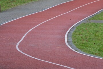 Running track curve with white lines and green grass