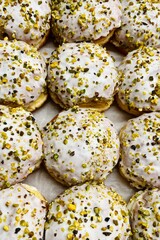 lots of donuts sprinkled with crushed pistachios. top view. calories. glaze
