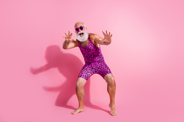 Full size photo of glamour senior man have fun dancing wear leopard print swimsuit isolated pink color background