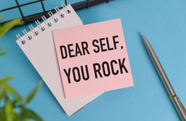 A pink sticky note with the words Dear Self, You Rock written on it