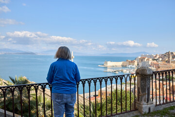 Fototapeta premium Person on Balcony Overlooking Ocean