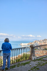 Fototapeta premium Person on Balcony Overlooking Ocean