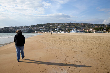 Person Walking on Sandy Beach with Ocean Views
