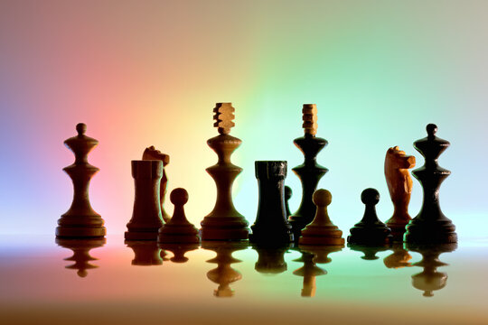 Chess pieces on reflective surface with colorful background