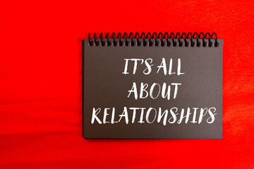 It’s all about relationships message written on black notebook page on red background. Conceptual it’s all about relationships symbol. Copy space.
