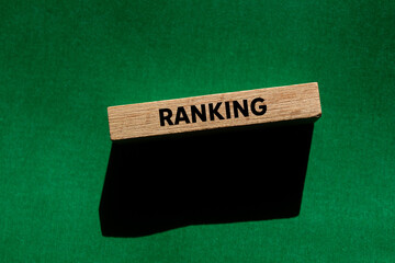 Ranking message written on wooden block on green background. Conceptual ranking symbol. Copy space.