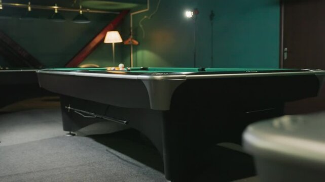 Capture of green pool tables in billiard room, with colorful billiard balls neatly arranged in triangle rack on one of the pool tables, creating a vibrant and inviting atmosphere for a game