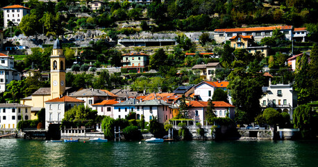 view of church and village along coast line of Lake Como Italy 