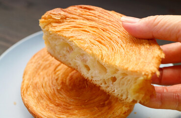 Hand Picking a Delectable Spiral Shaped Supreme Croissant