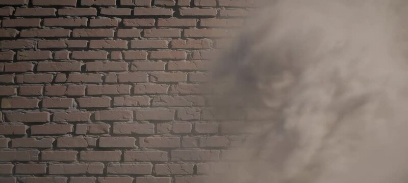 Brick wall in sunlight with passing shadow and dust movement
