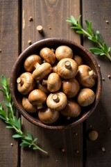 Obraz premium A Bowl of Brown Mushrooms on a Wooden Surface with Herbs