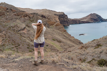 Fototapeta premium Hiking woman on the island with views over rocks and sea.