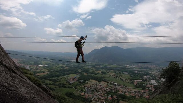 Climber on the Tibetan bridge of via Ferrata Guido Rossa