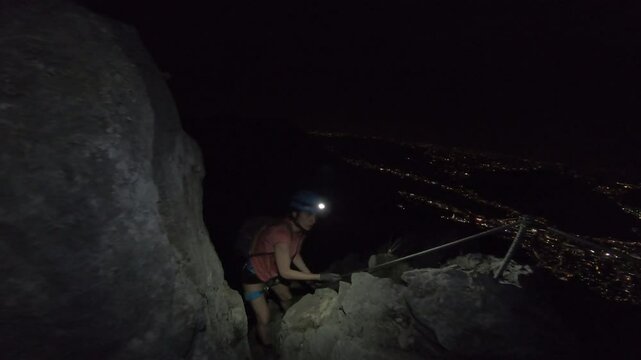 Female Climber by night on Via Ferrata Gamma 1, Piani d'Erna, Italy
