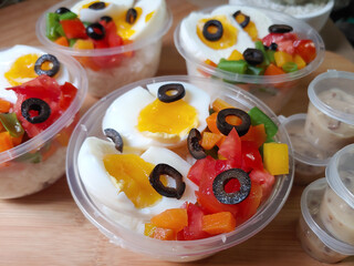 Vegetable salad with pouch boiled eggs and black olive in plastic cup