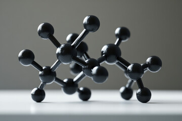 A 3D model of a molecule, showcasing interconnected black spheres representing atoms and bonds.
