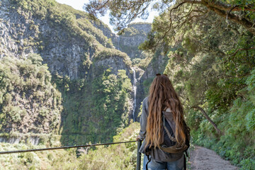 Naklejka premium Woman hiking in nature to a beautiful waterfalls.
