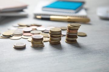 Stack of coins on the desk with a business objects.