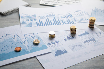 Stack of coins with a financial growth graphs.