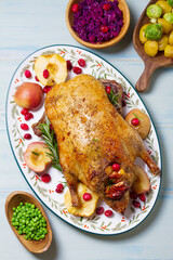 Roasted duck with apples and cranberries served with peas, red cabbage and potatoes. View from above, top view