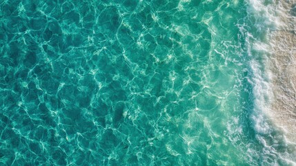 Aerial view of a beach with turquoise water and sandy shore under bright sunny skies